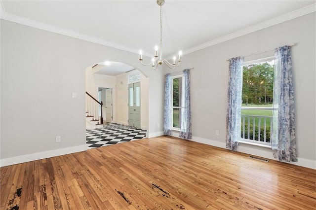 unfurnished room featuring crown molding, light hardwood / wood-style flooring, and a chandelier