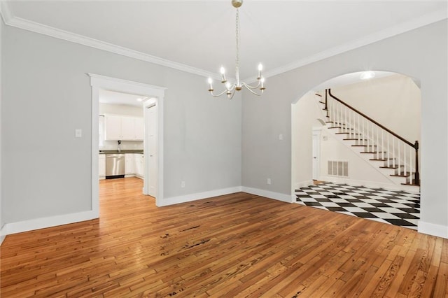 interior space featuring light wood-type flooring, a chandelier, and crown molding