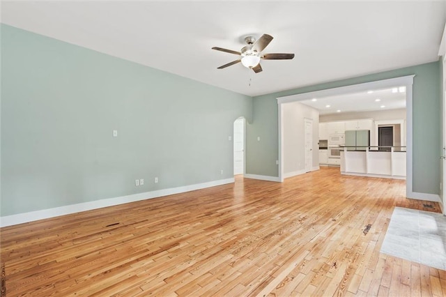 unfurnished living room with light wood-type flooring and ceiling fan