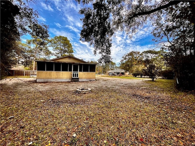 exterior space with a fire pit and a sunroom