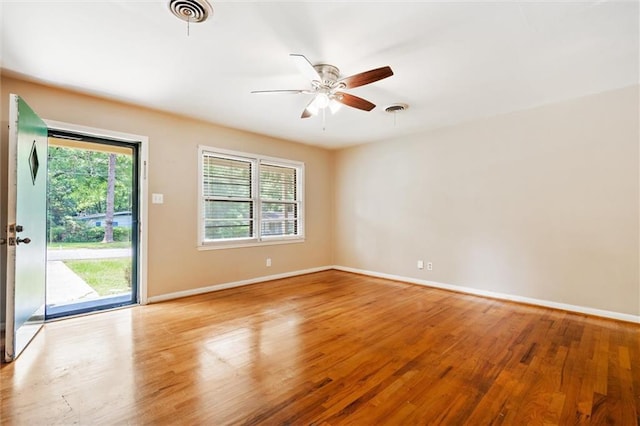 unfurnished room featuring visible vents, a healthy amount of sunlight, and wood finished floors