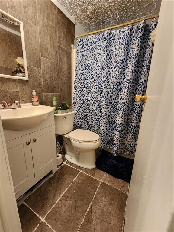8560 Sadie Ct, Grand Bay, AL 36541 - full bathroom with vanity, tile walls, and curtained shower