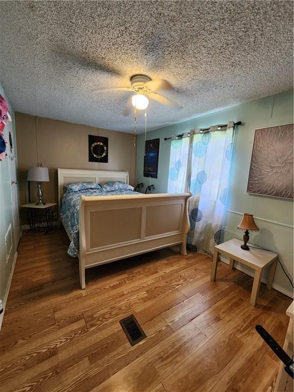 8560 Sadie Ct, Grand Bay, AL 36541 - bedroom with wood finished floors, ceiling fan, and a textured ceiling