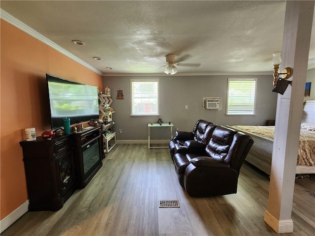 8560 Sadie Ct, Grand Bay, AL 36541 - living room featuring plenty of natural light, wood finished floors, a ceiling fan, a wall unit AC, and crown molding
