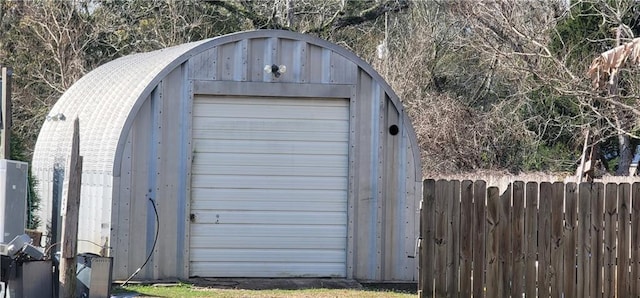 view of outbuilding with fence and an outbuilding