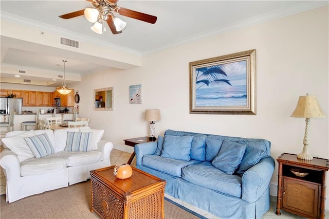 carpeted living room with ceiling fan and ornamental molding