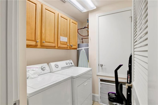 clothes washing area with cabinets and independent washer and dryer