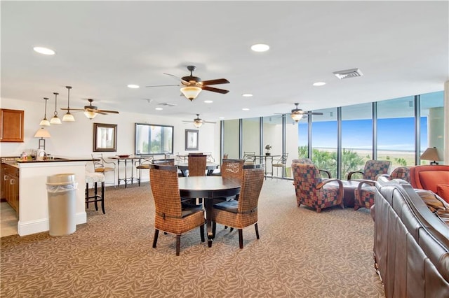 carpeted dining room with ceiling fan