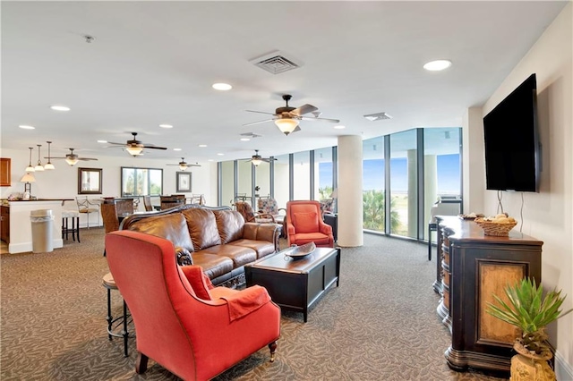 carpeted living room with a wall of windows and ceiling fan