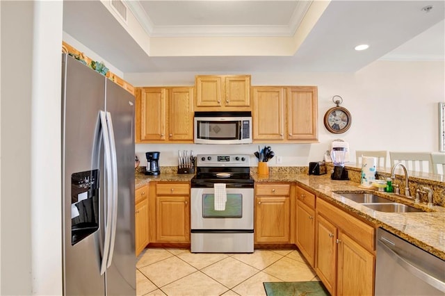 kitchen with ornamental molding, light stone counters, sink, and appliances with stainless steel finishes