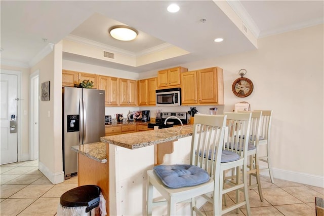 kitchen with a kitchen breakfast bar, stainless steel appliances, light stone countertops, and ornamental molding