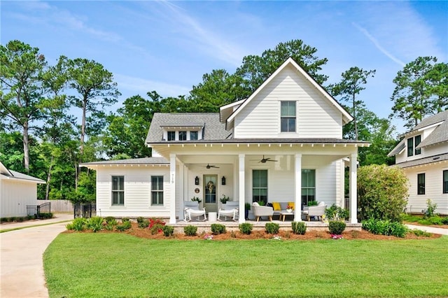 modern inspired farmhouse with ceiling fan, covered porch, and a front yard