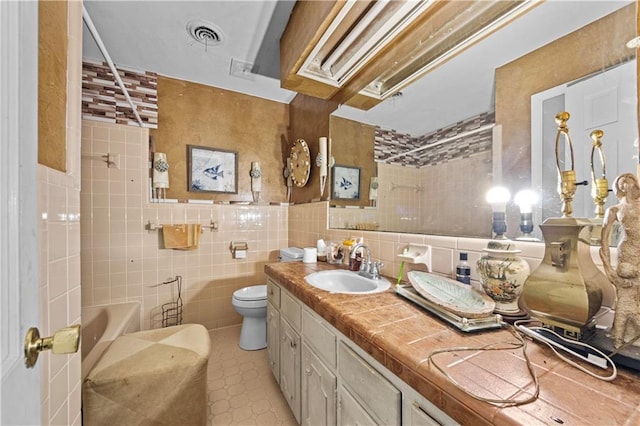 full bathroom with vanity, toilet, shower / bathing tub combination, and tile walls