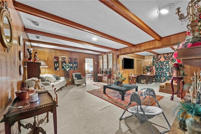 living room with light carpet, a textured ceiling, wooden walls, and beamed ceiling