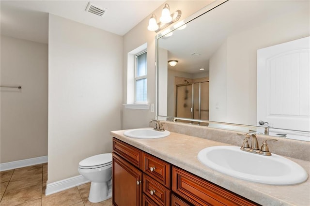 bathroom with tile patterned flooring, vanity, a shower with shower door, and toilet