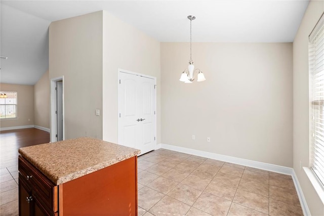 kitchen with a chandelier, pendant lighting, high vaulted ceiling, and light tile patterned flooring