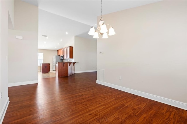 interior space with a notable chandelier, dark wood-type flooring, and high vaulted ceiling