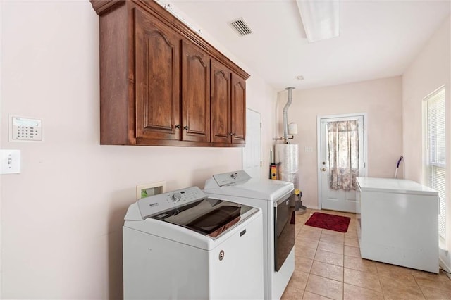 218 Ferry Ave, Saraland, AL 36571 - laundry area featuring washer and dryer, cabinet space, water heater, and light tile patterned flooring