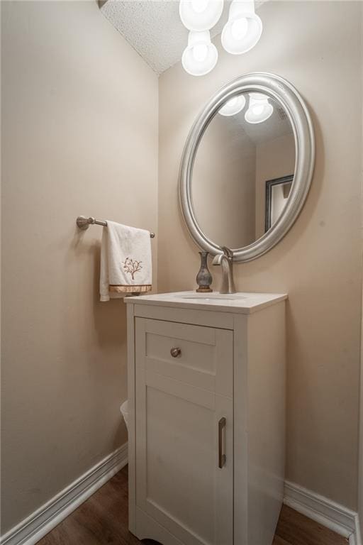 bathroom featuring hardwood / wood-style flooring, a textured ceiling, and vanity