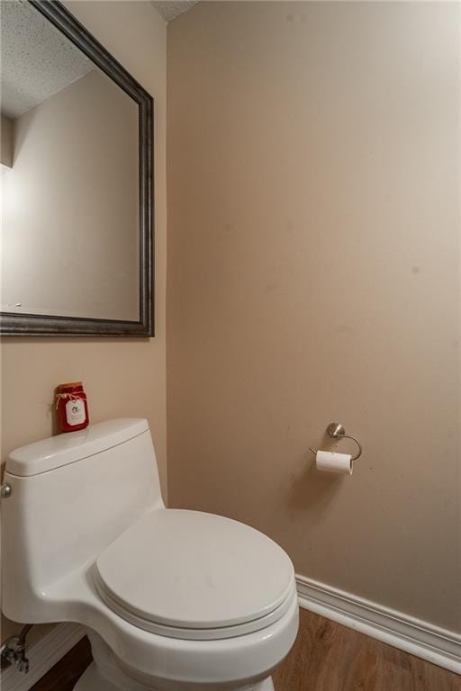 bathroom with toilet, a textured ceiling, and hardwood / wood-style flooring