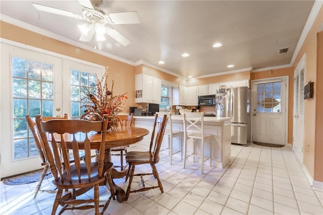 tiled dining space with ceiling fan, french doors, and ornamental molding