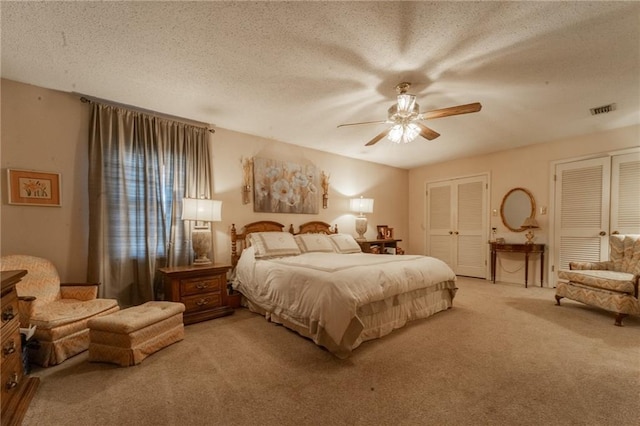 carpeted bedroom with ceiling fan and a textured ceiling