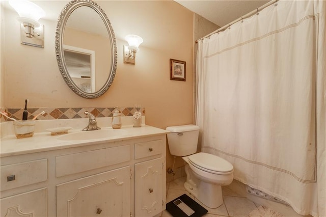 bathroom with toilet, vanity, and tile patterned flooring