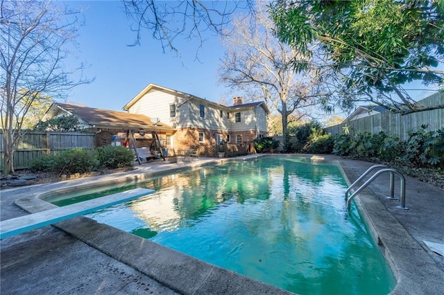 view of pool with a patio area and a diving board