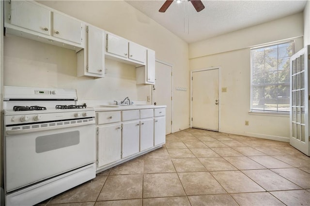 2852 Exter Dr, Mobile, AL 36606 - kitchen featuring white range with gas cooktop, a sink, light tile patterned floors, healthy amount of natural light, and a textured ceiling