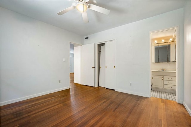 2852 Exter Dr, Mobile, AL 36606 - unfurnished bedroom with wood finished floors, baseboards, a sink, connected bathroom, and a closet