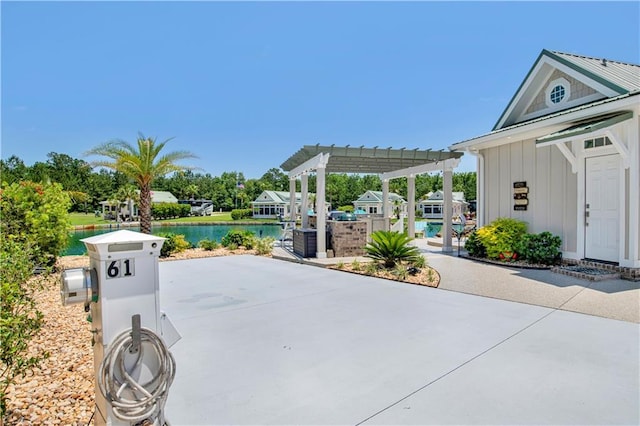 view of patio featuring a pergola and a water view