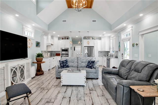 living room featuring a wealth of natural light, light hardwood / wood-style flooring, and high vaulted ceiling