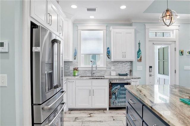 kitchen featuring pendant lighting, white cabinetry, sink, light stone countertops, and high end fridge