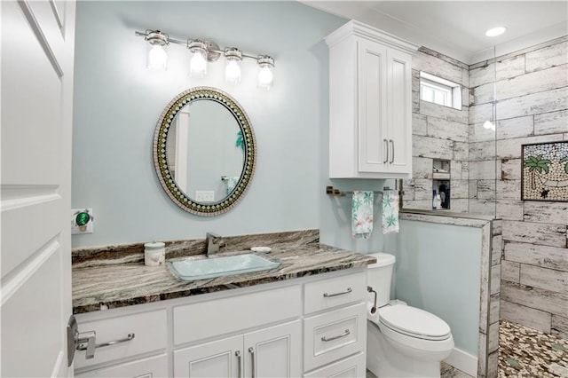 bathroom with vanity, toilet, and a tile shower