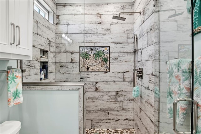 bathroom with toilet and a shower with shower door