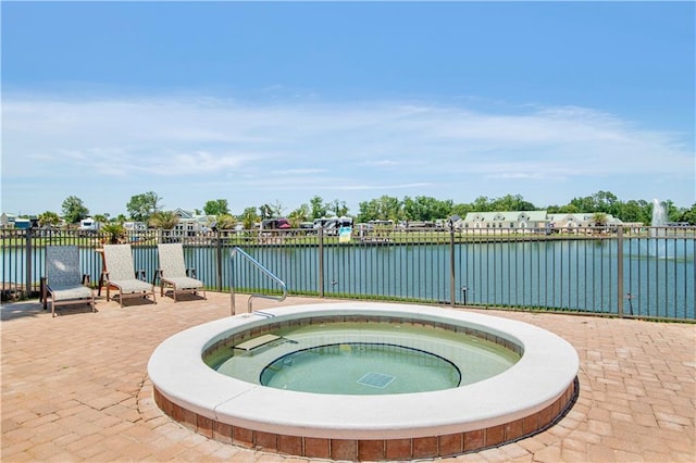 view of swimming pool with a water view, a hot tub, and a patio