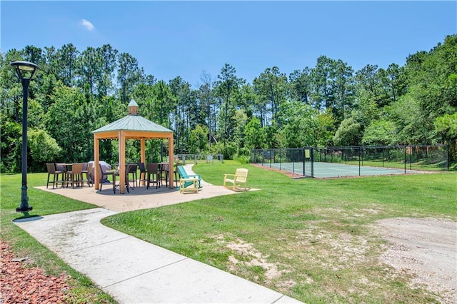surrounding community featuring a yard, a gazebo, and tennis court