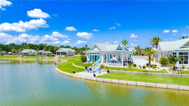 back of house featuring a patio, a water view, and a yard