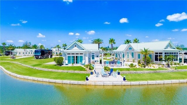 back of house featuring a patio, a water view, and a yard