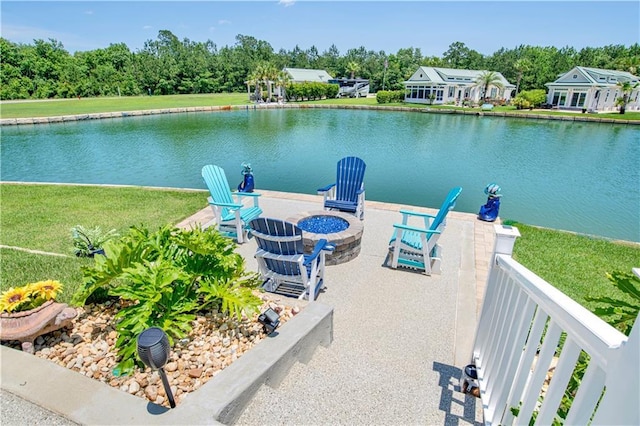 view of dock featuring a patio, a water view, a yard, and an outdoor fire pit