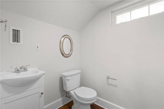 2203 Dauphin St, Mobile, AL 36606 - half bathroom with vaulted ceiling, baseboards, vanity, wood finished floors, and toilet