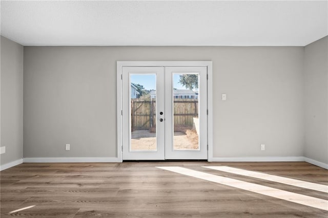 unfurnished room with french doors and hardwood / wood-style flooring