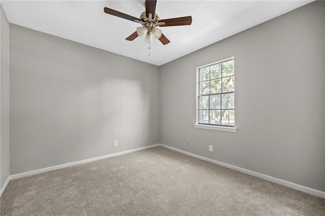 carpeted spare room featuring a textured ceiling and ceiling fan