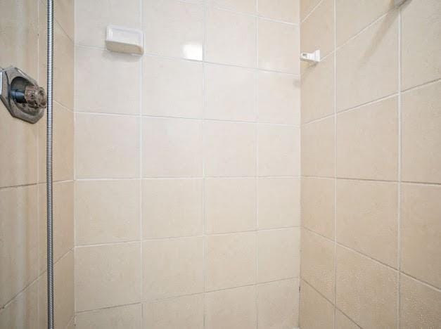 interior details featuring a tile shower