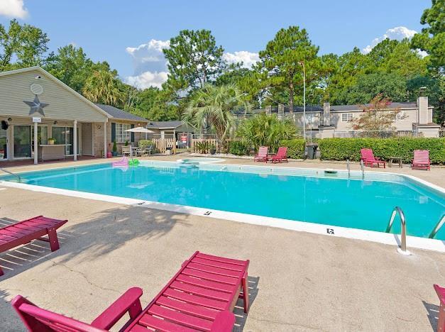 community pool with a patio area and fence