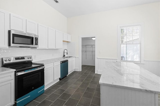 1012 Texas St, Mobile, AL 36604 - kitchen with white cabinets, dark tile patterned floors, light stone countertops, and appliances with stainless steel finishes