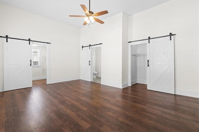 1012 Texas St, Mobile, AL 36604 - unfurnished bedroom with baseboards, a high ceiling, connected bathroom, a barn door, and wood finished floors