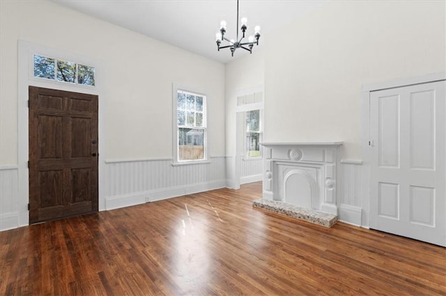 1012 Texas St, Mobile, AL 36604 - unfurnished living room with a wainscoted wall, wood finished floors, and a notable chandelier