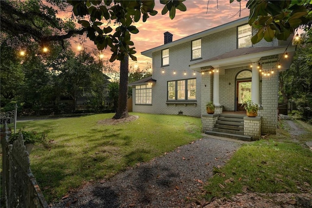264 Mcdonald Ave, Mobile, AL 36604 - view of front facade with brick siding, a chimney, and a front yard