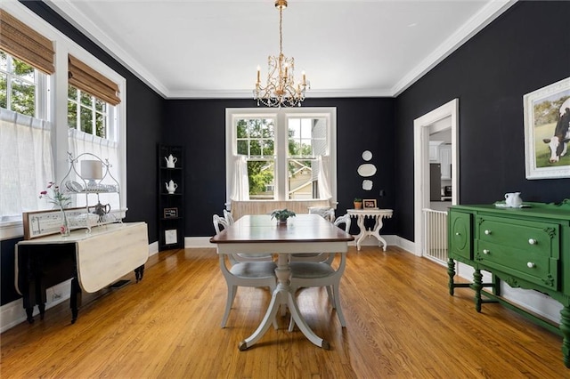 264 Mcdonald Ave, Mobile, AL 36604 - dining space featuring a chandelier, light wood finished floors, healthy amount of natural light, and crown molding